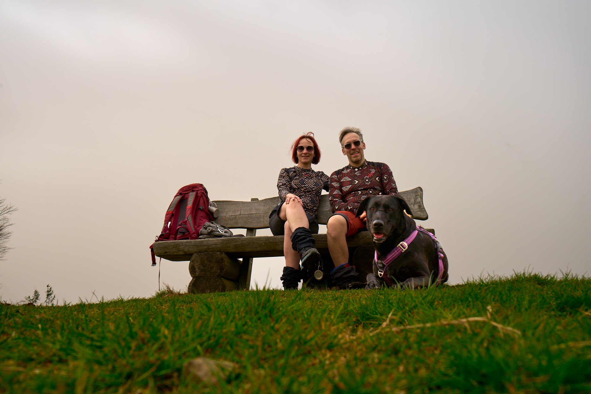 wir auf einer Bank und im Vodergrund Polly auf einer Wiese